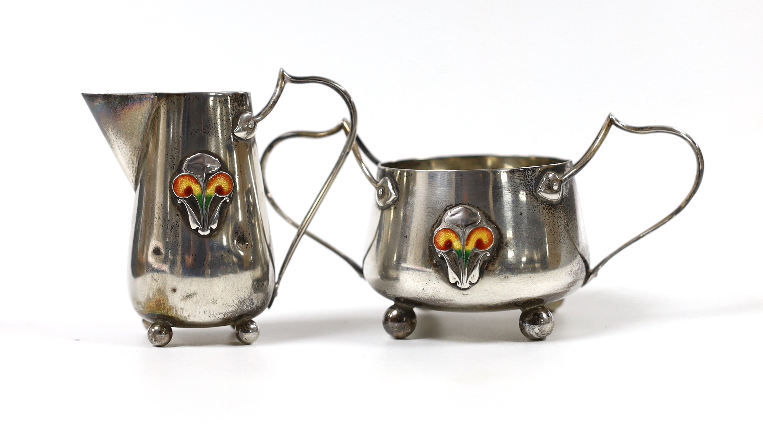 An Edwardian Art Nouveau silver and enamelled cream jug and sugar bowl, C & Co, Birmingham, 1905, jug height 76mm, gross weight 123 grams.